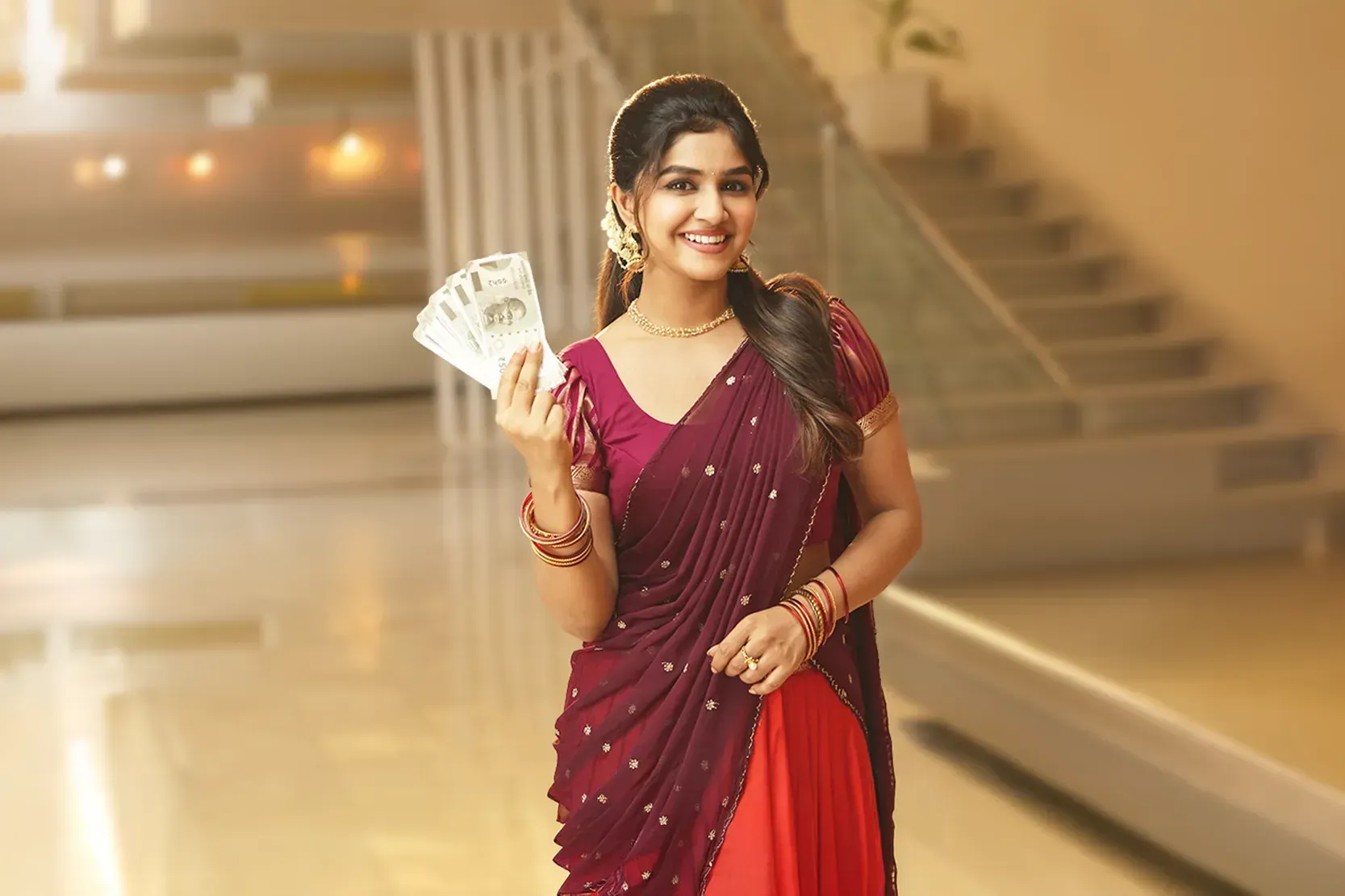 Woman holding cash after choosing the best gold buyers in Bangalore.